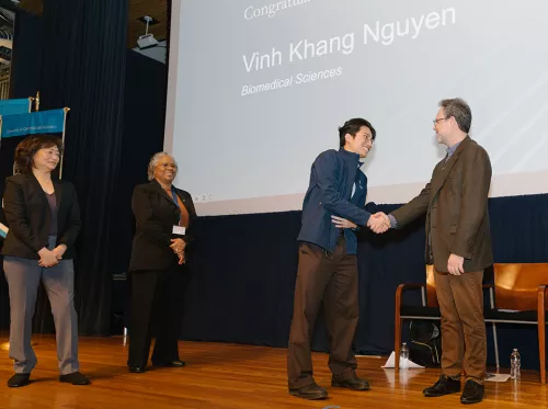 Adrian Erlebacher (right) congratulates student Vinh Khang Nguyen after coating