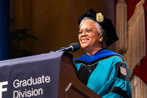 Nicquet Blake speaks at podium in regalia