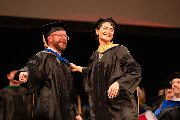 Adviser and student after hooding at commencement
