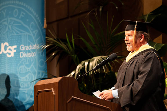 Mike Taigman, MA, offers remarks from the stage at commencement