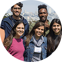 a group of five young people smiling for a photo